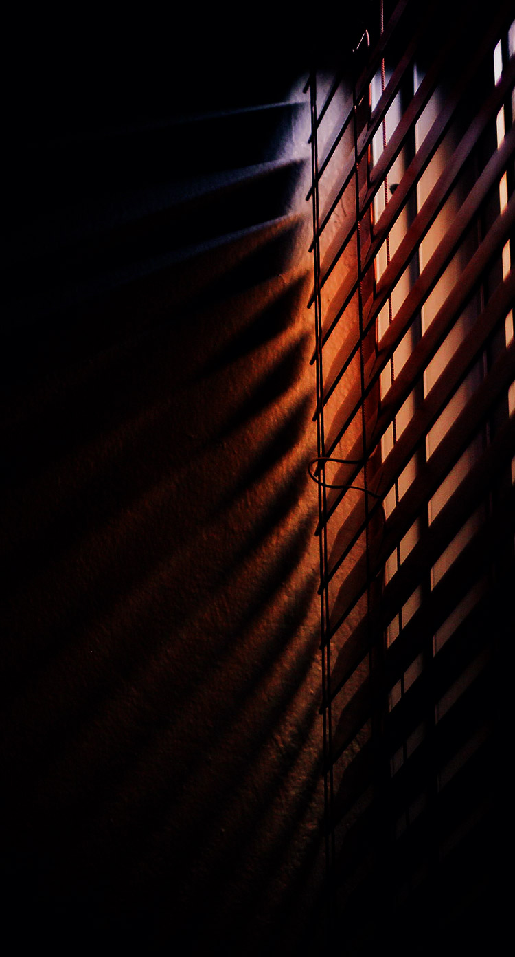 A dark window with orange and blue light coming in