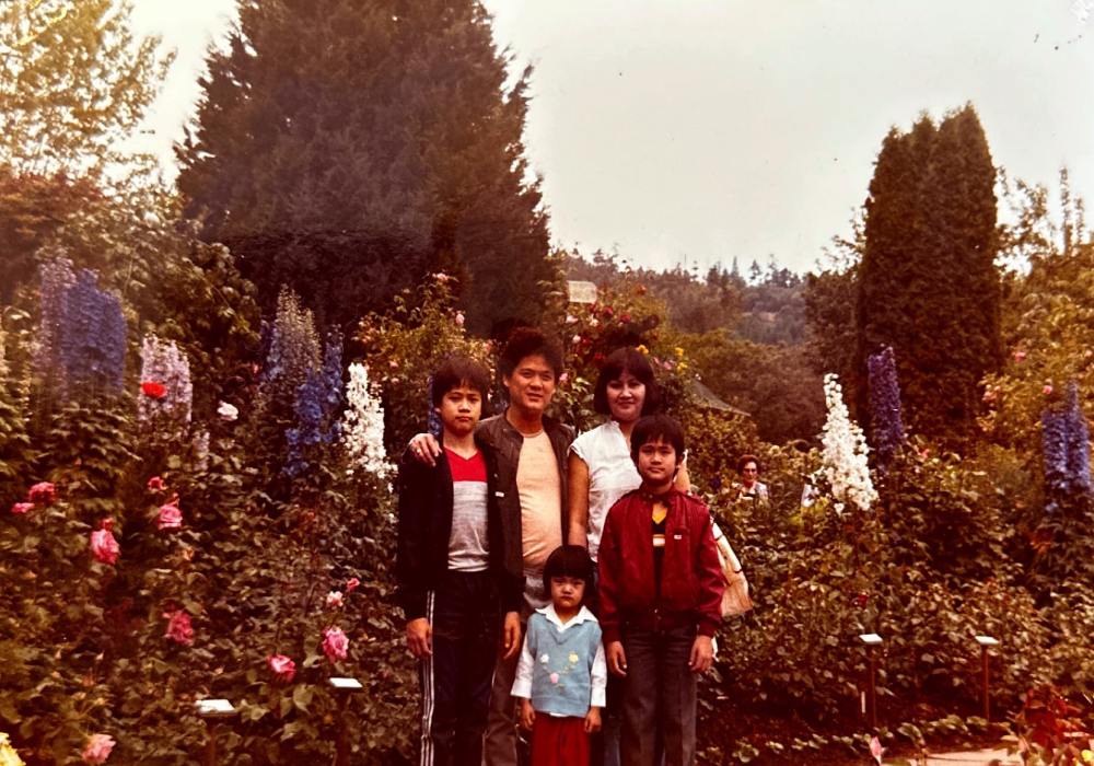 A portrait from the late-1980s of a family at a park in the spring.