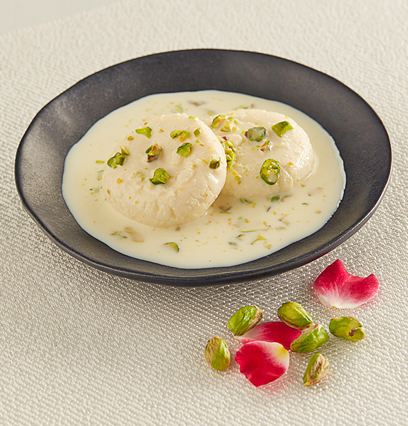 A dish of cheese patties in a rich cream, dopped with pistachios.