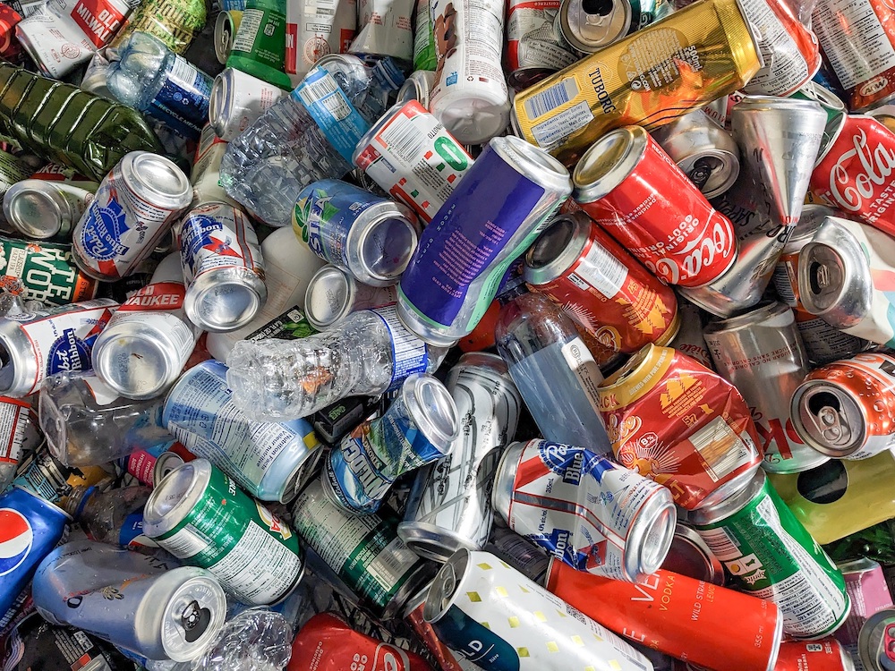  A close up of an assortment of cans: Coke, Pepsi, water bottles and various beers.