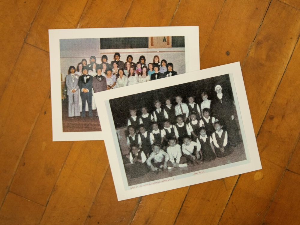 Two school photos are arranged on a wooden floor.