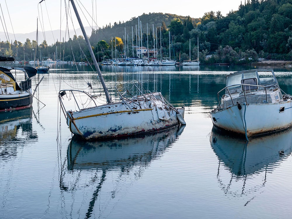 Derelict boats sinking into the water.
