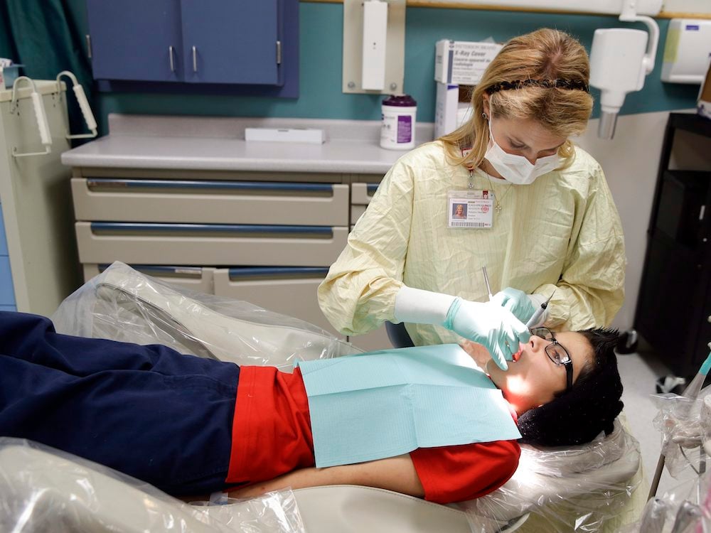 A dentist treats a child.