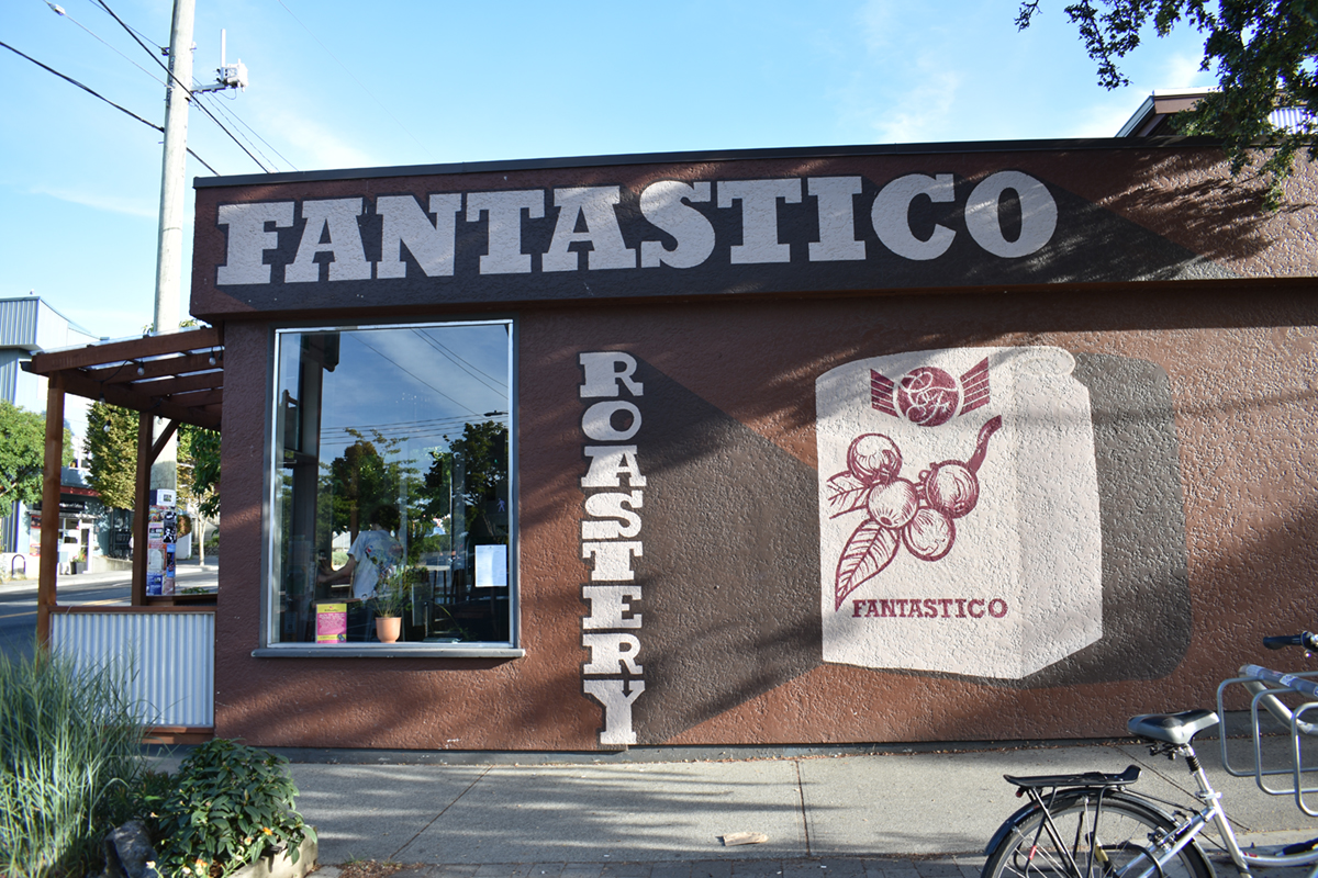 The outside of Caffe Fantastico. The walls are painted in rich browns, reminiscent of coffee. ‘FANTASTICO ROASTERY’ is painted on the wall.
