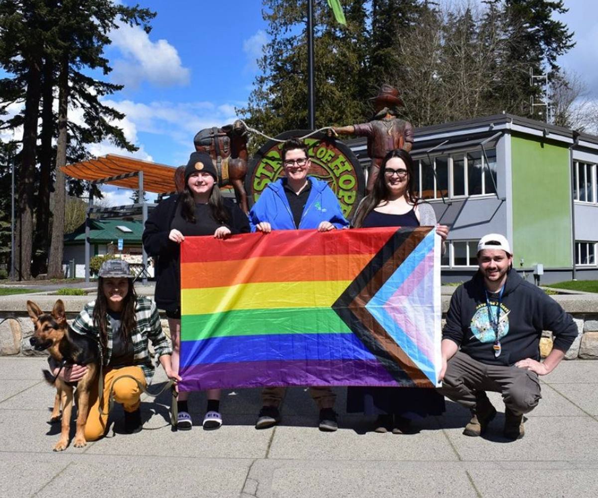 Five people (and a dog) pose with a pride flag in Hope, B.C.
