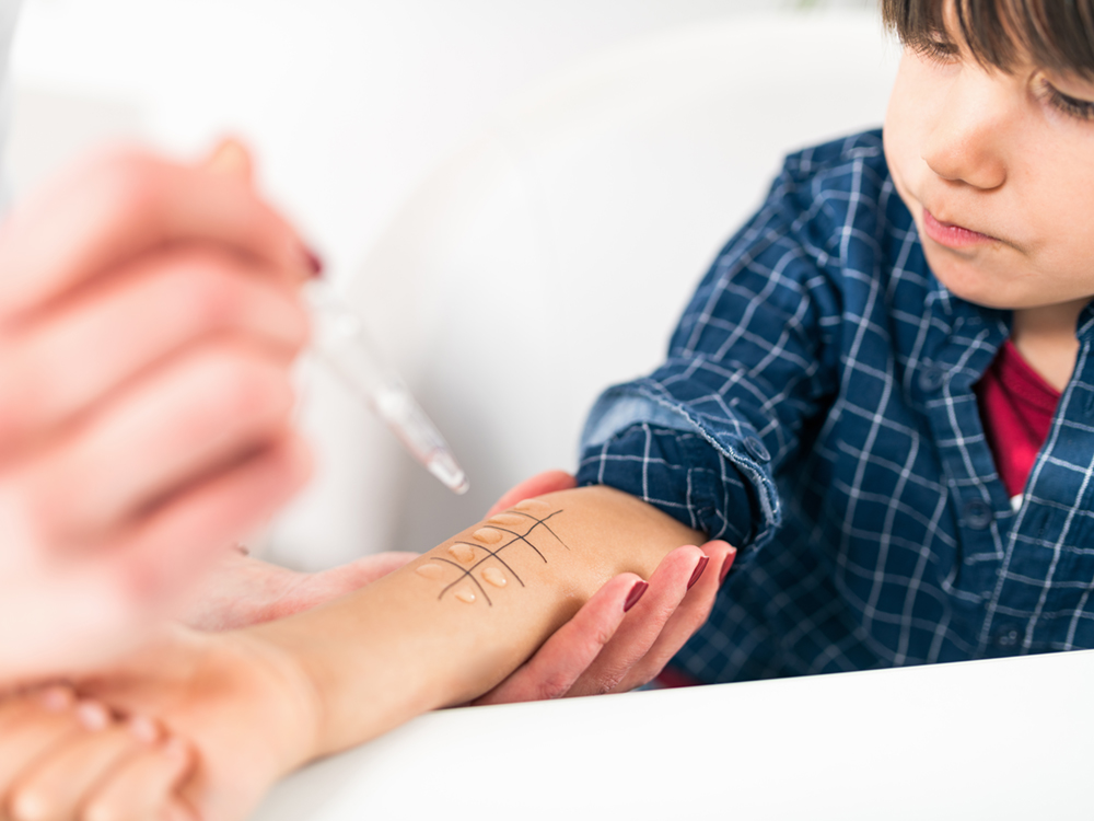 A child is being given a skin prick test for allergies.