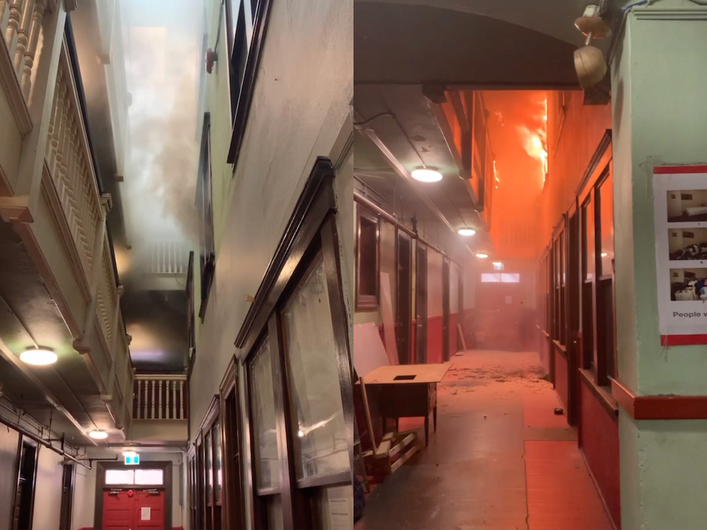 Two images grabbed from a video are side by side. On the left there is a long hall and tall narrow atrium with railings on each floor, with smoke at the top. On the right is a hall with smoke and flames already leaping out into the atrium.