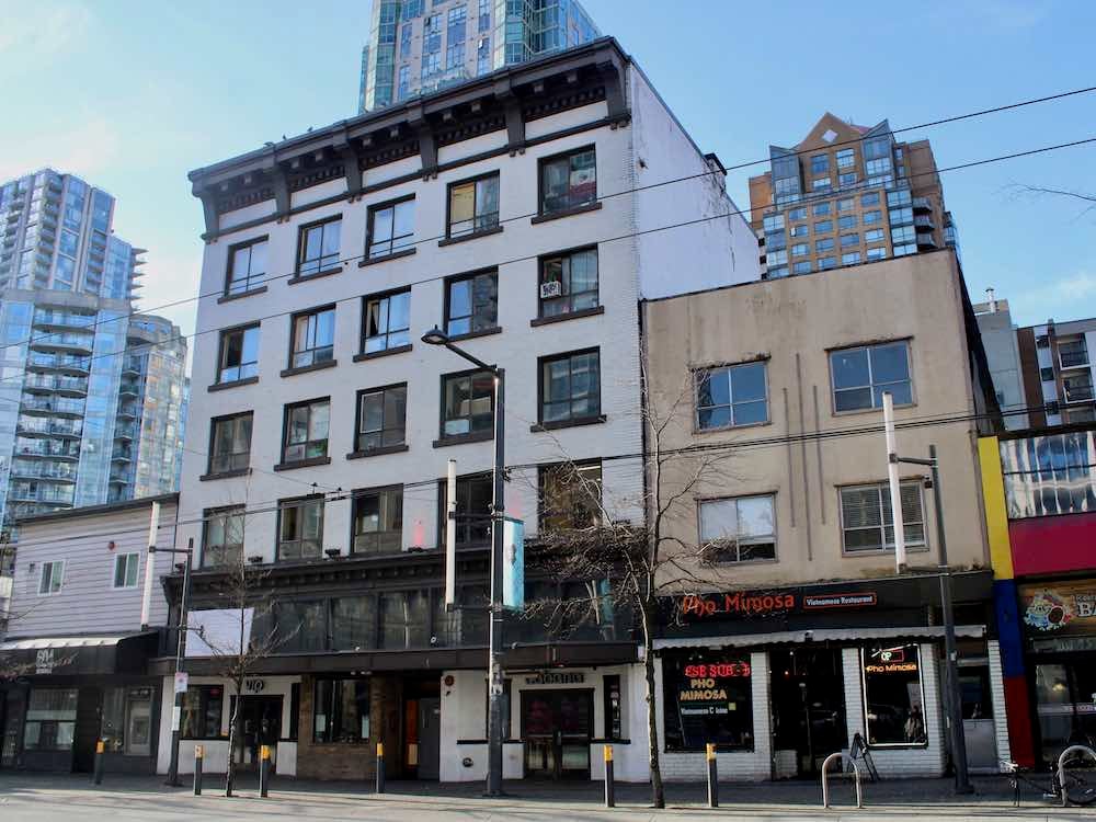 A 110-year-old hotel stands on Vancouver’s Granville Street. It’s white, with brown-trimmed windows regularly spaced on the facade.