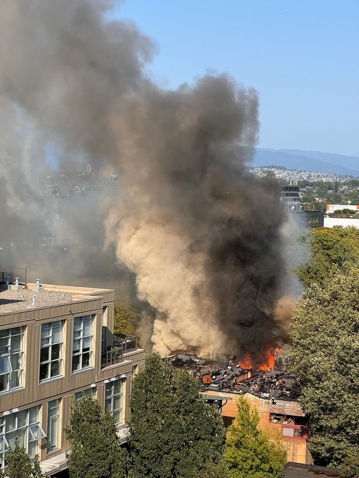 An overhead view shows black and beige smoke rising from an apartment fire.