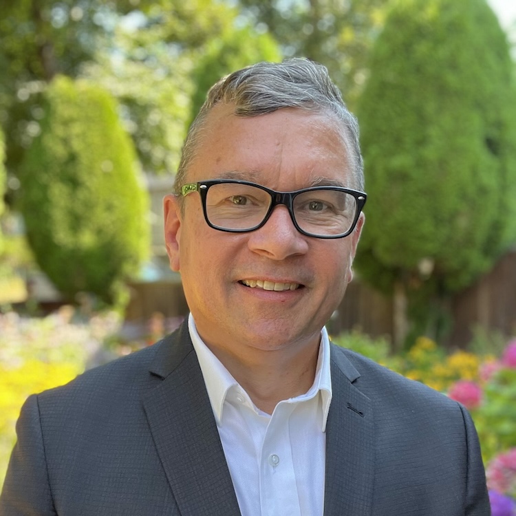 A headshot of Councillor Mike Klassen. He is wearing a grey blazer, white dress shirt, and glasses.