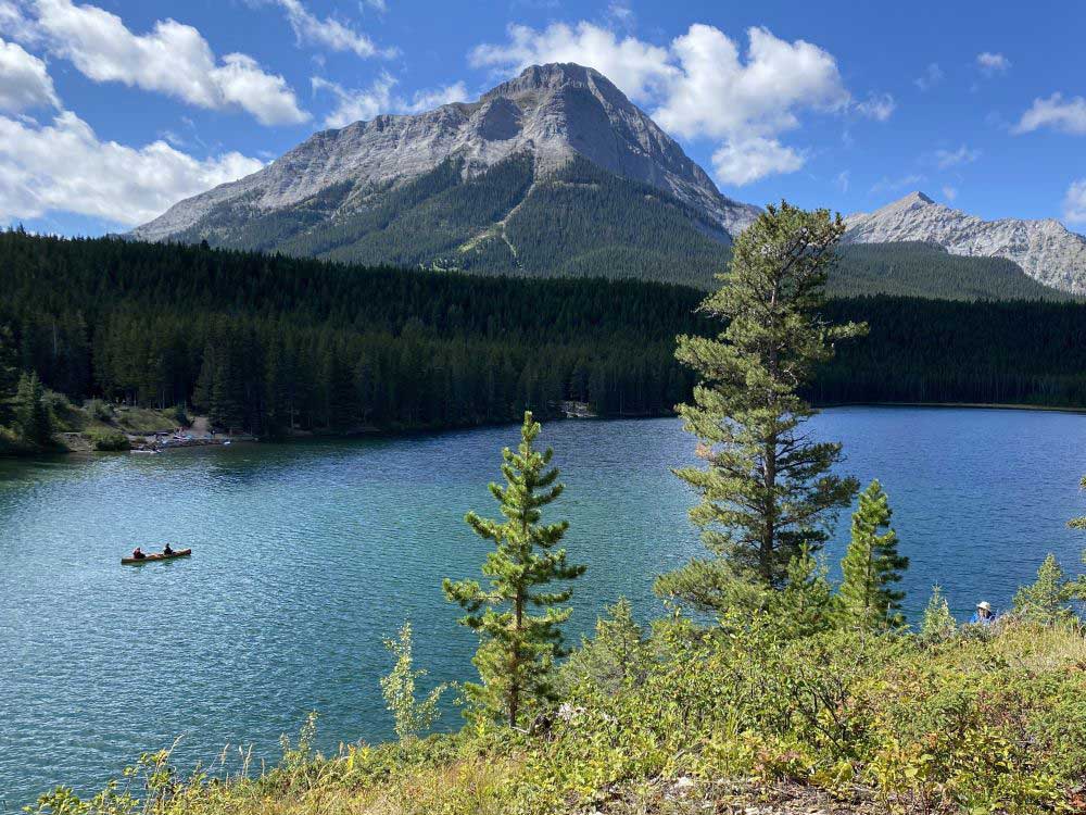 Two people canoe in a lake in the Crowsnest area.