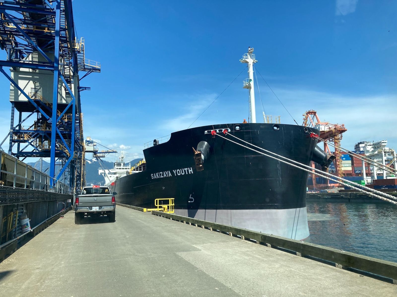 A cargo ship alongside a port berth. The words ‘Sakizaya Youth’ appear on the side of the vessel.