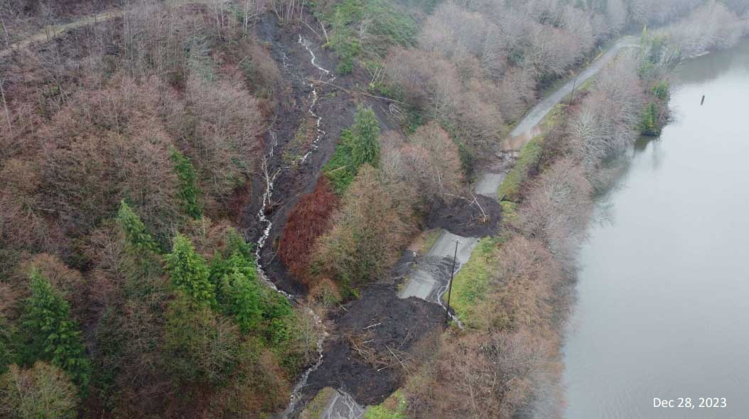 An aerial photo shows a muddy landslide covering a road.