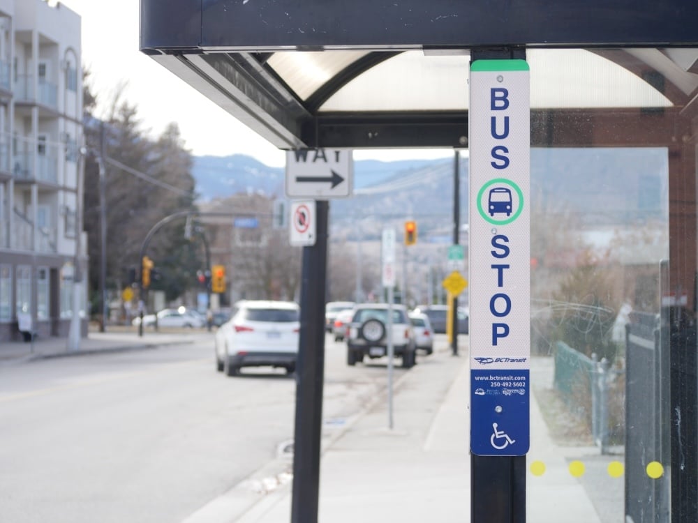 A close-up of a vertical bus stop sign.