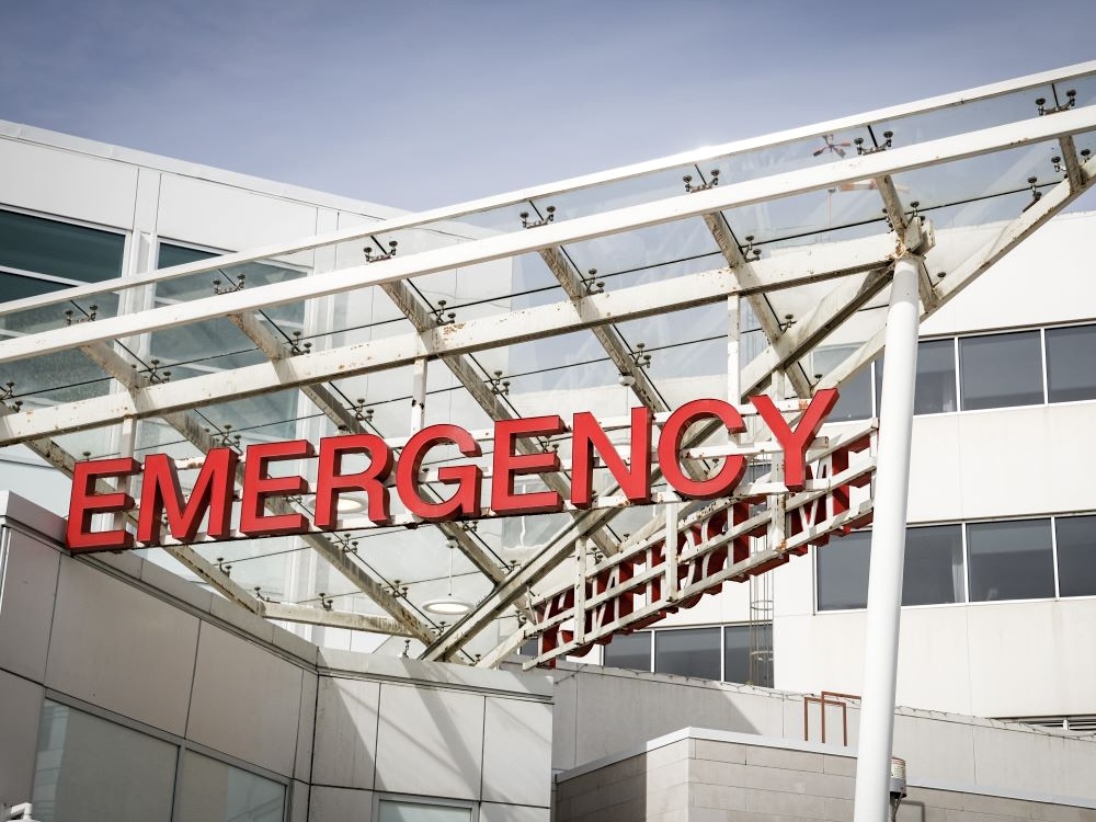 A red &lsquo;Emergency&rsquo; sign on a white hospital building.
