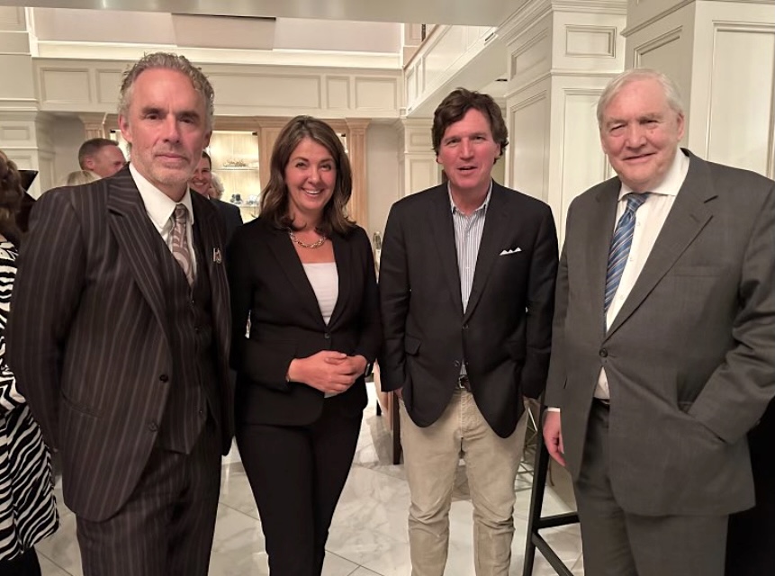 Four people stand looking at the camera in a fancy setting.