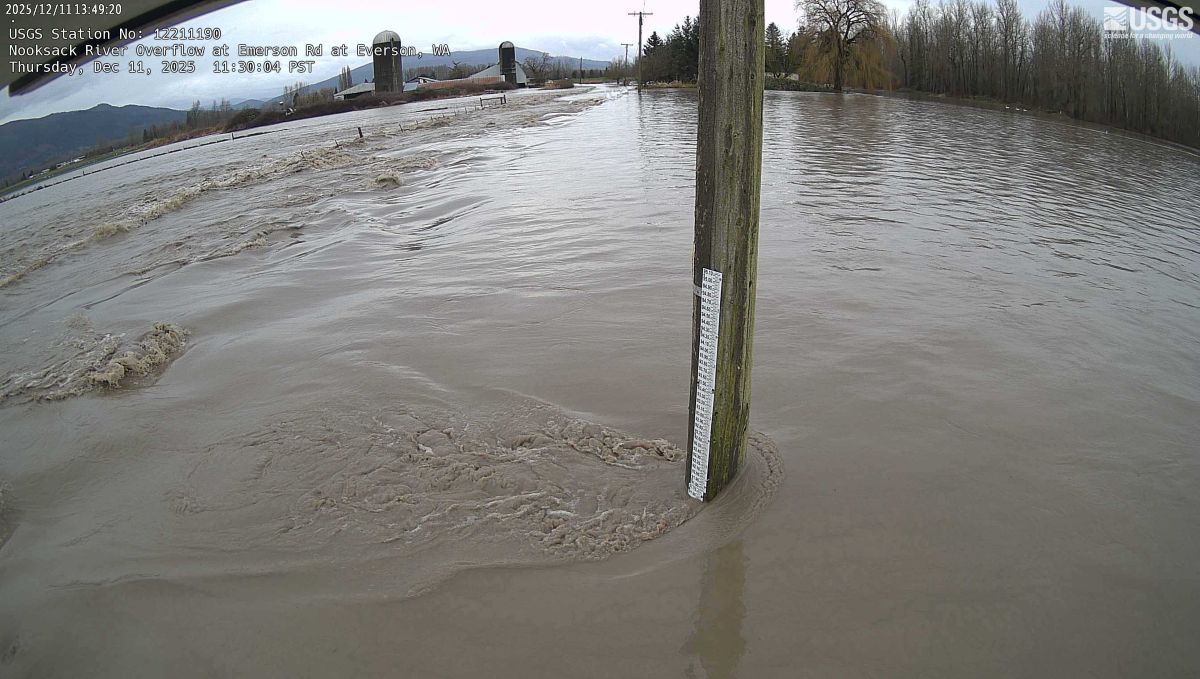 Rushing floodwater completely covers farmer’s fields, ticking up a flood level marker.