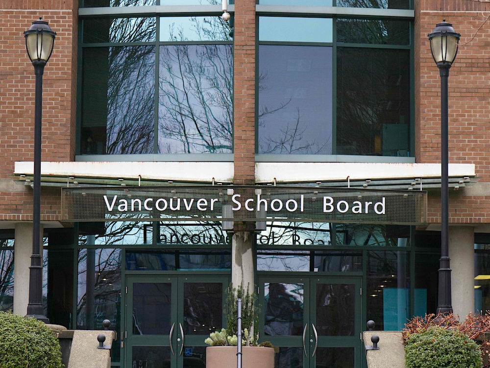 A modern brick building with a sign that reads &lsquo;Vancouver School Board.&rsquo;