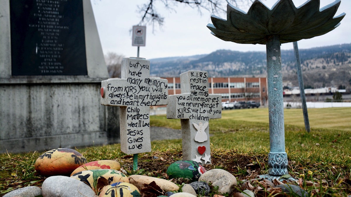 Two stone crosses with messages about former students who attended Kamloops Indian Residential School.