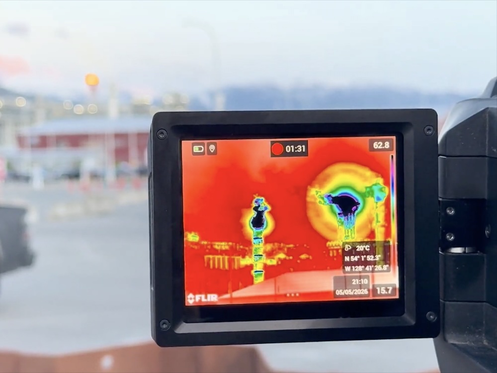 On a screen, black, purple, blue, green and yellow are visible in a sort of layered cloud around the LNG facility, reflecting pollutants visible through a special gas imaging camera.