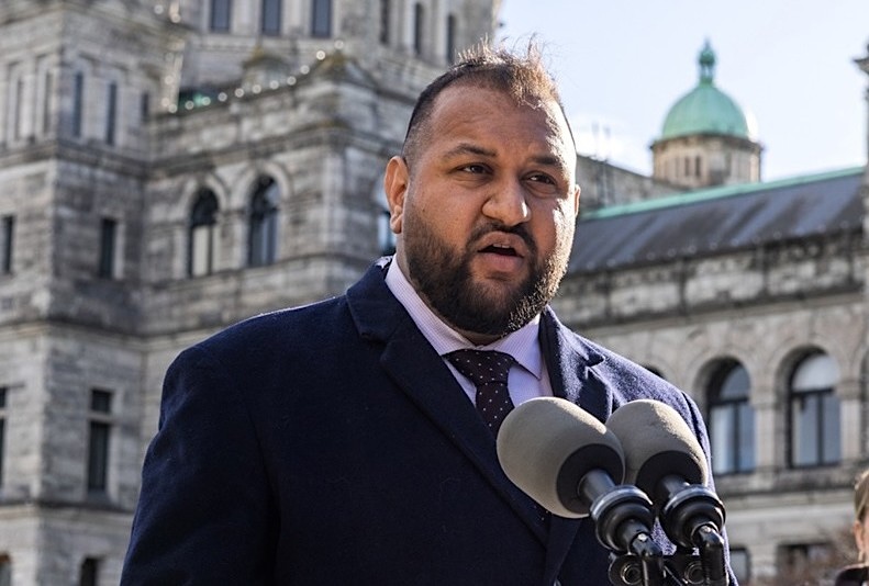 A South Asian middle-aged man, Ravi Parmar, speaks in front of the B.C. legislature.