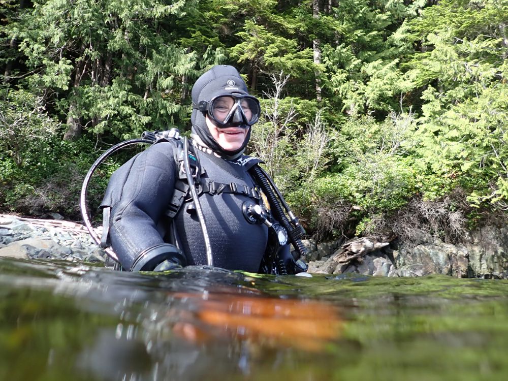 Jackie Hildering wears a dry suit and stands waist-deep in ocean water.