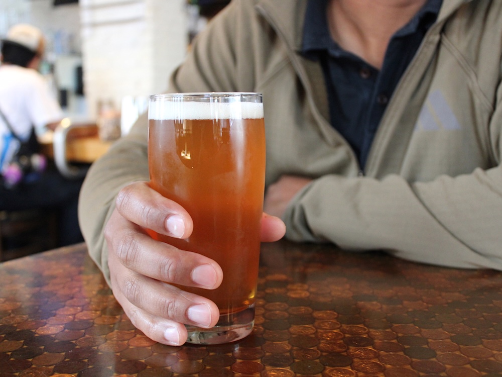 A person holds a pint of beer.