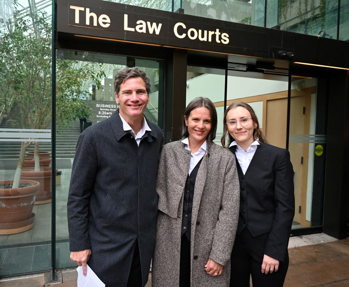 DULF&rsquo;s three lawyers smile and pose for a photo in front of the Vancouver courthouse.