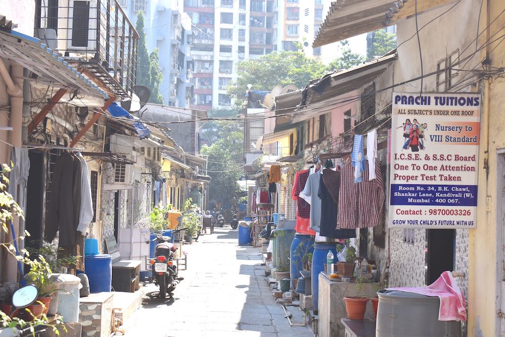 A sunny alleyway hung with laundry. Beige buildings fill in the scene.