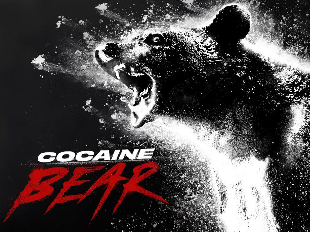 A black and white image shows a crazed looking bear and masses of white powder. The words ‘Cocaine Bear’ are superimposed.