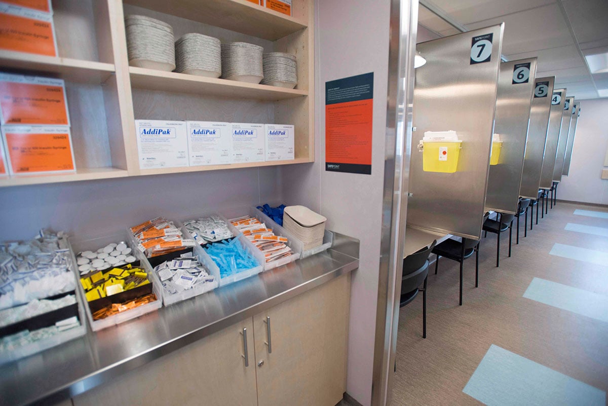 A photo shows a tidy assortment of medical supplies and a row of desks and chairs, separated by stainless steel dividers.