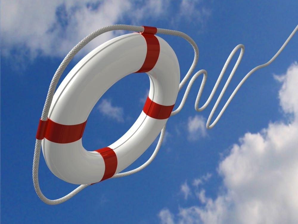 A white lifebuoy with red bands attached to a rope is in mid-air, with blue sky visible above.