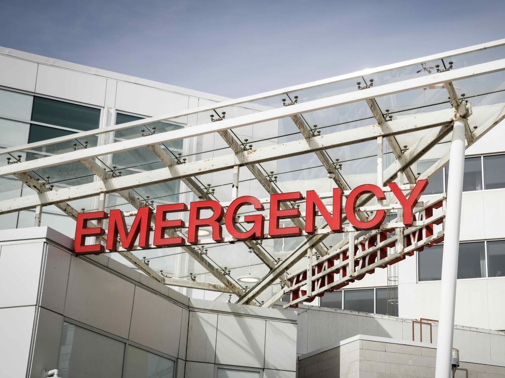 Bright red letters spell out &ldquo;Emergency&rdquo; in front of a hospital.