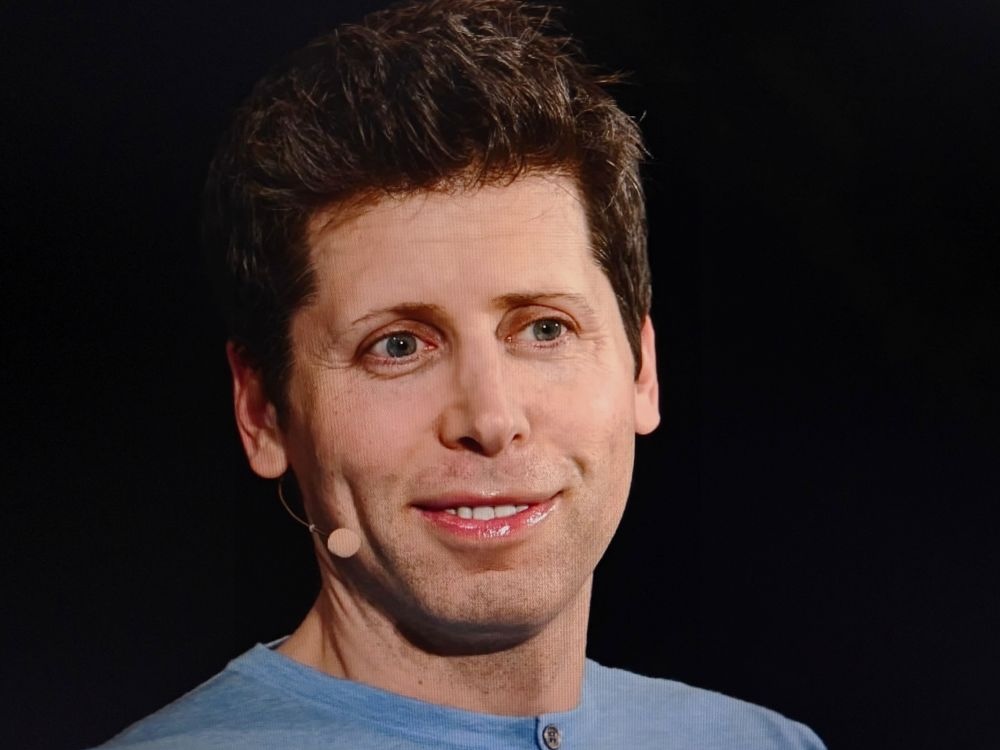 A 40-year-old light-skinned man wearing a light blue T-shirt, with dark hair and facial stubble.