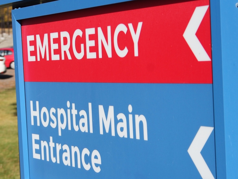 A sign outside a hospital says &lsquo;Emergency&rsquo; in white capital letters on a red background.