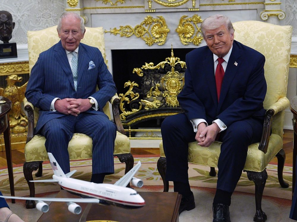 King Charles and Donald Trump sit in armchairs in an ornately decorated room.