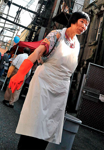 A woman drags trash in Chinatown