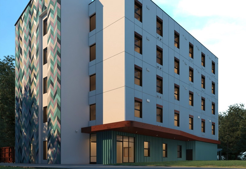A five-storey white building stands on a city block. One side is painted to reflect interwoven triangles.