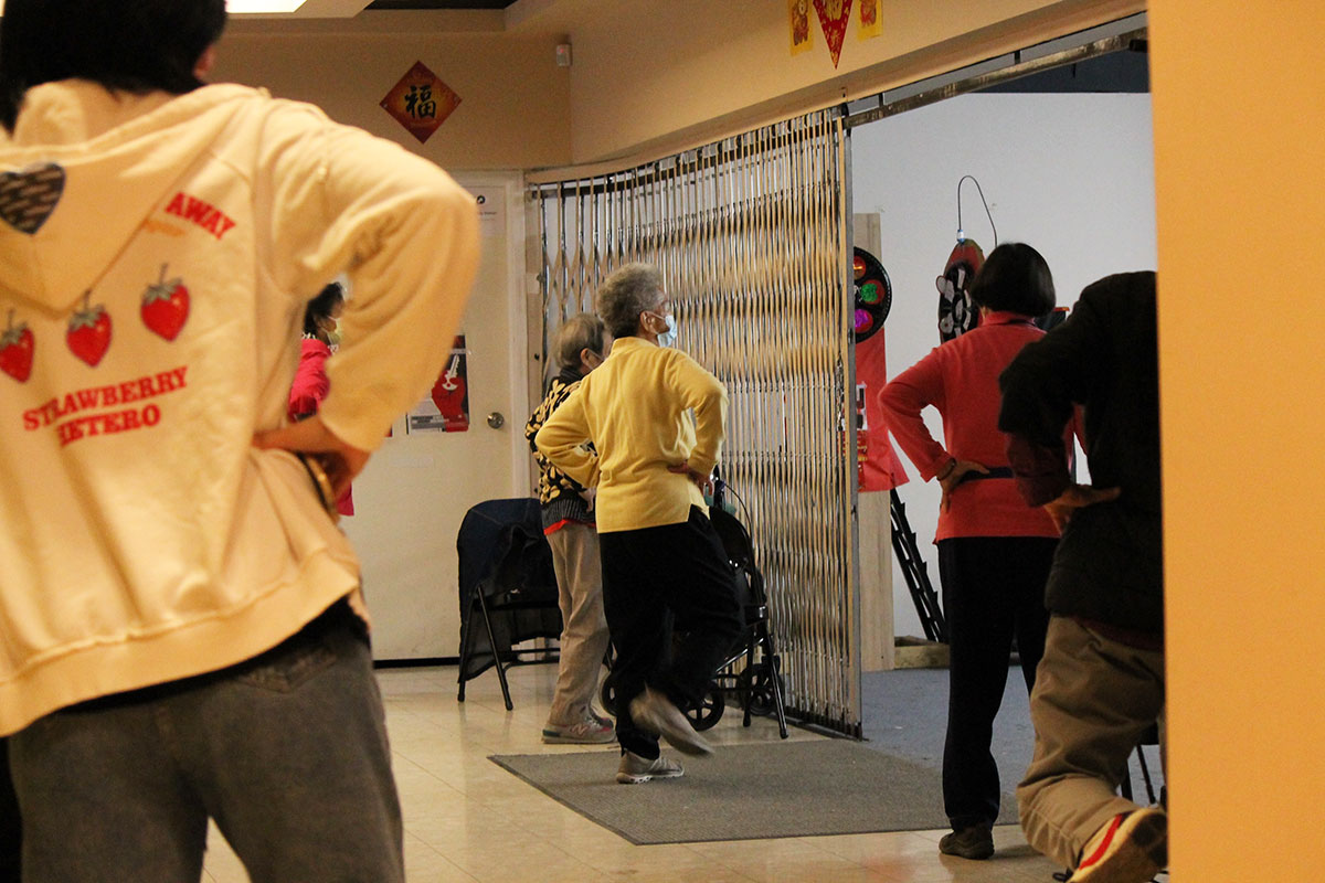 A group of people exercising in a yellow room.