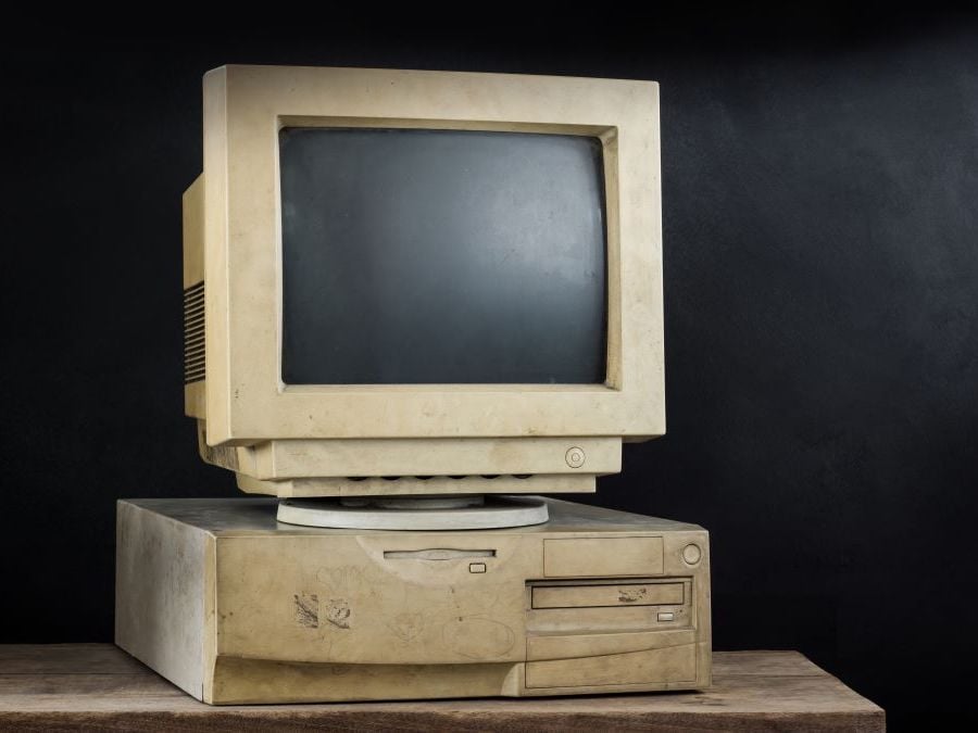 An old-school desktop computer, with a clunky square monitor sitting on top of the box hard drive.
