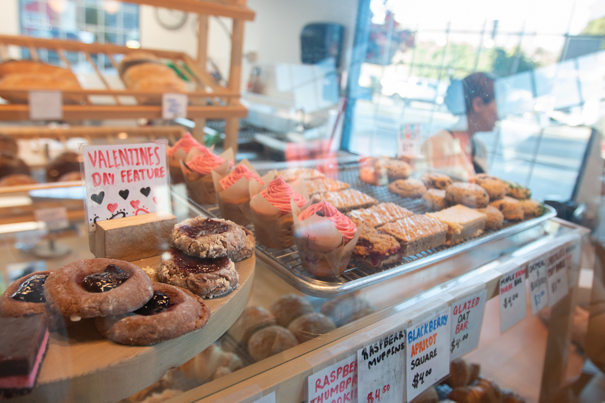 A closeup of the bakery case shows thumbprint cookies, raspberry muffins and more.