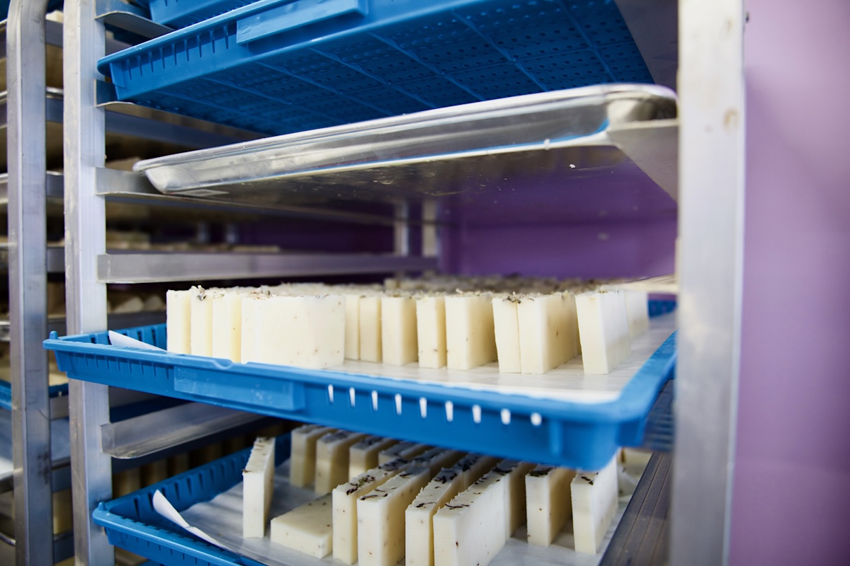 Sliced soap bars on a large cart with trays.