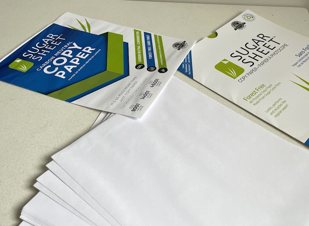 A table displays sheets of sugar cane copy paper.