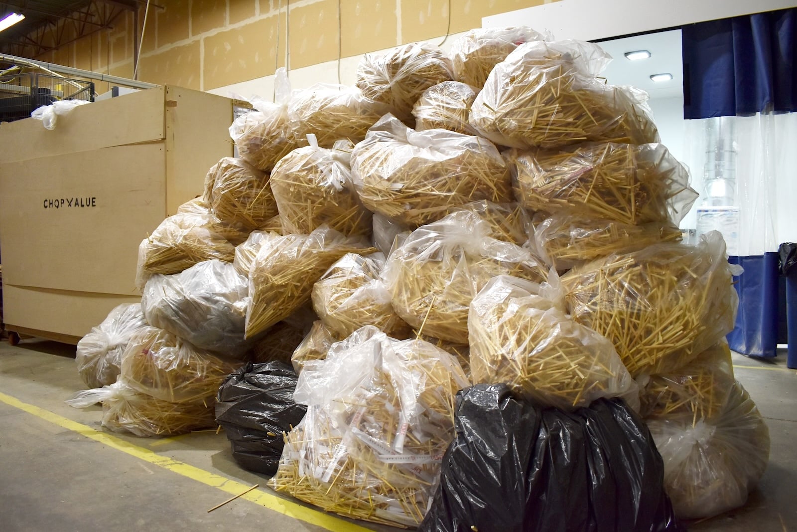 A large stack of plastic bags full of chopsticks in a Vancouver warehouse.