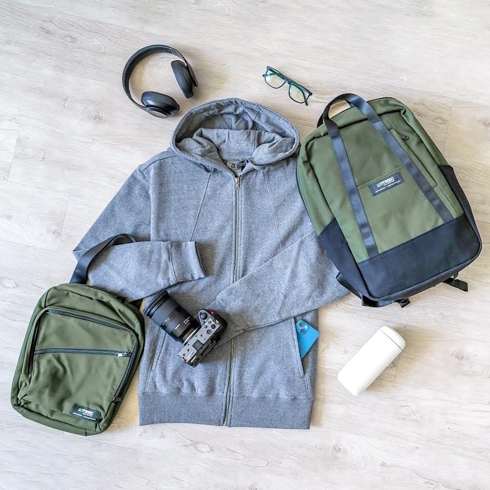 A T-shirt and two bags lie on the ground. The bags have Looptworks branding on them.