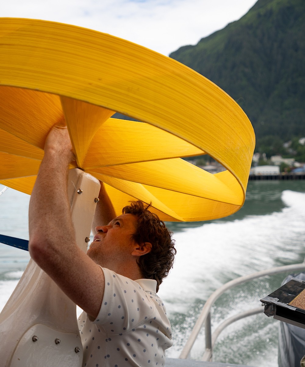 Lance McMullan tinkers with a section of his power-generating ocean devices on the back of a boat in coastal Alaska. 