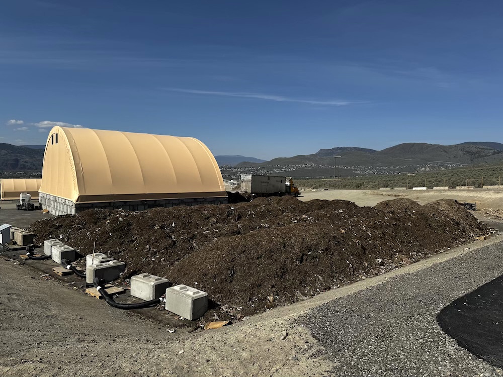There are three rows of compost in the middle of the Stsw&eacute;kstem facility. There&rsquo;s a tent and a truck in the distance. The composting is about to be sent wholesale to consumers.  